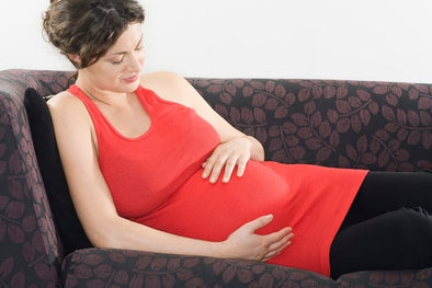 Pregnant woman sitting on a seat with her legs raised