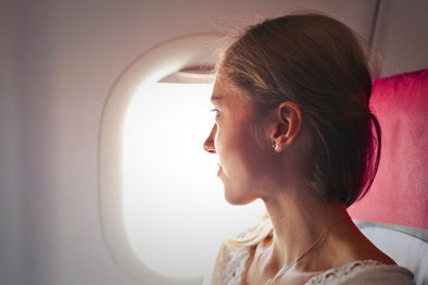 Female passenger looking out a plane window