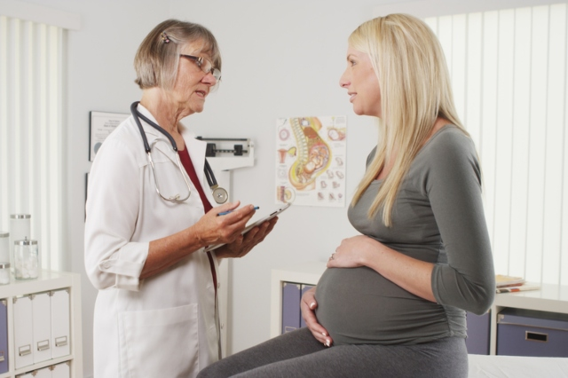 Woman doctor talking to her pregnant patient