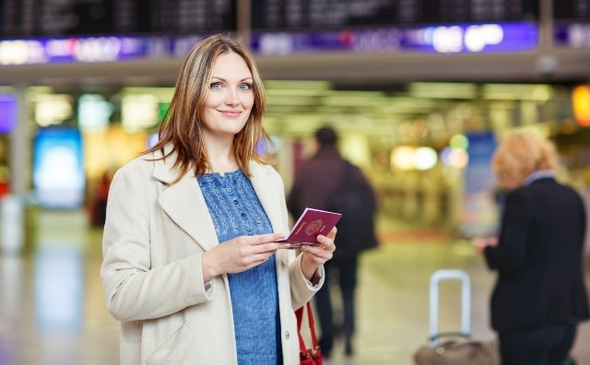 Woman standing in airport with her passport